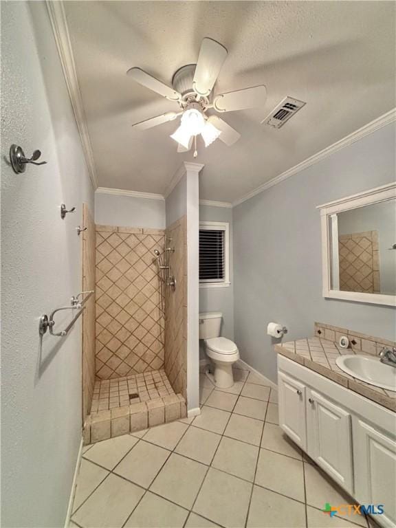 bathroom with tiled shower, ornamental molding, tile patterned flooring, and vanity