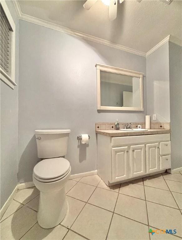 bathroom featuring crown molding, ceiling fan, tile patterned flooring, vanity, and toilet