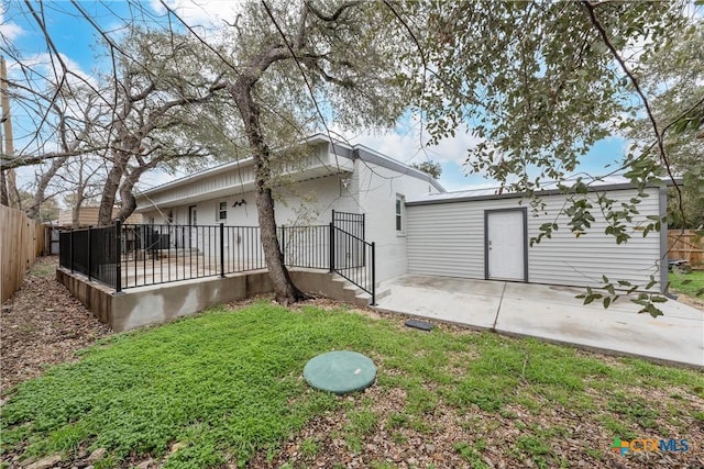 rear view of property with a yard and a patio area