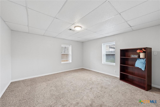 unfurnished room with carpet and a drop ceiling