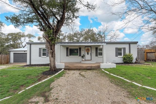 single story home with a garage, covered porch, and a front lawn