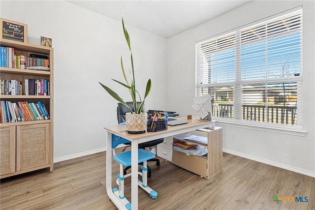 dining area featuring light wood finished floors and baseboards