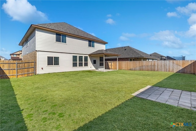 back of property featuring a yard, a patio area, and a fenced backyard