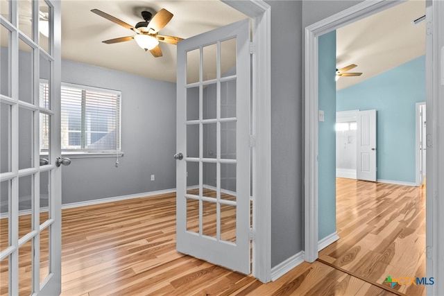 interior space with ceiling fan, vaulted ceiling, light wood-type flooring, and french doors