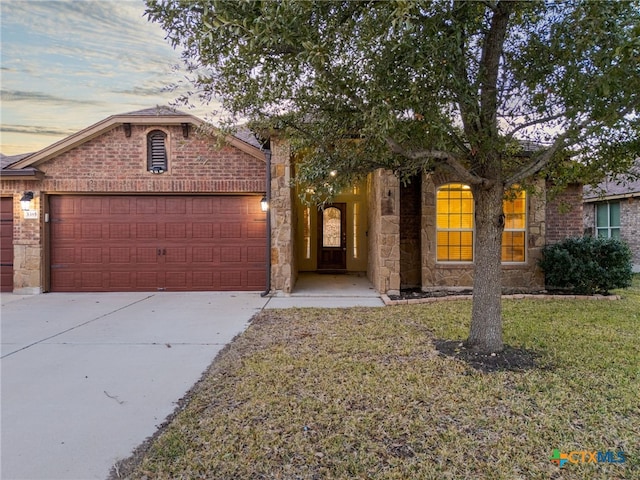 view of front of property featuring a garage and a lawn