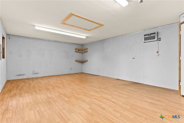 spare room with a wall mounted AC and light hardwood / wood-style floors