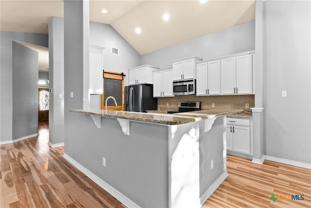 kitchen featuring white cabinetry, tasteful backsplash, kitchen peninsula, and appliances with stainless steel finishes