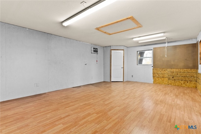 unfurnished room featuring hardwood / wood-style flooring and a wall unit AC