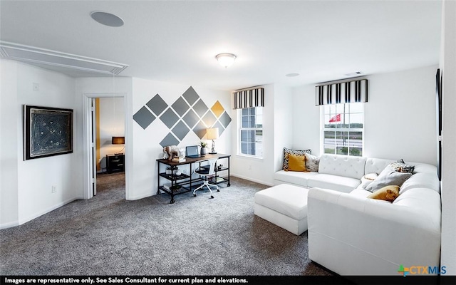 carpeted living area with baseboards and attic access