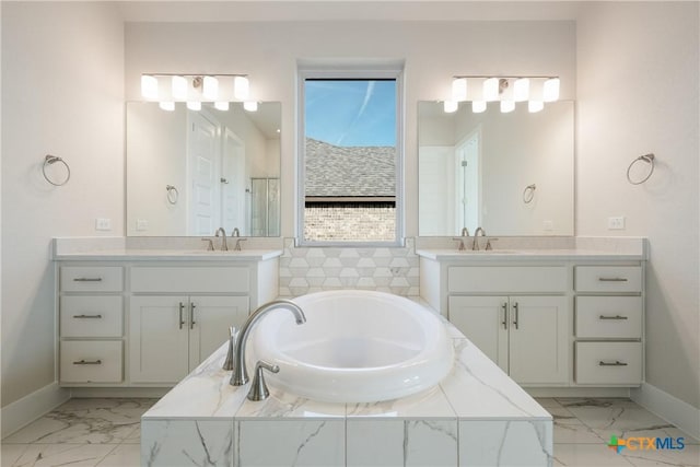 bathroom with vanity and tiled tub