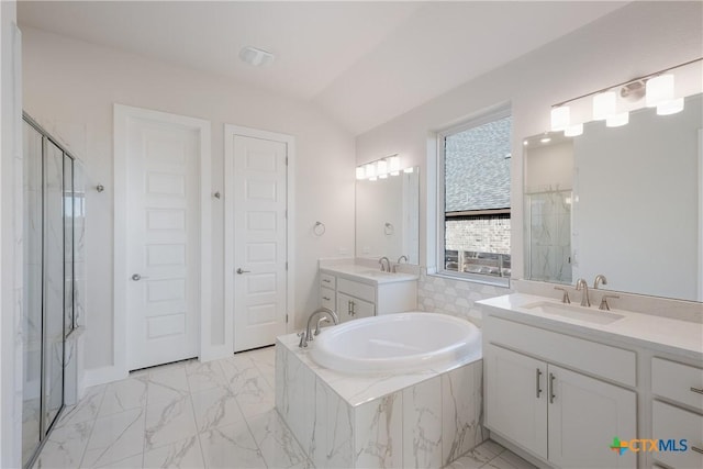 bathroom with vanity, vaulted ceiling, and independent shower and bath