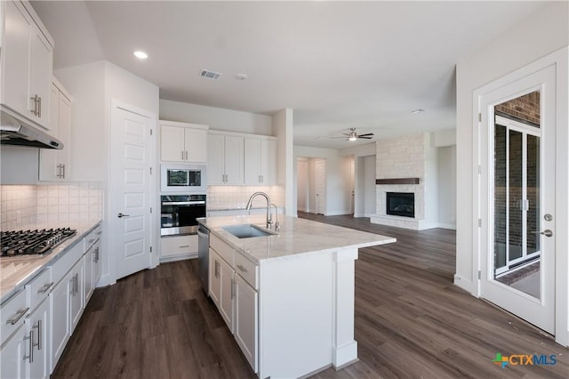 kitchen featuring a kitchen island with sink, sink, appliances with stainless steel finishes, tasteful backsplash, and white cabinetry