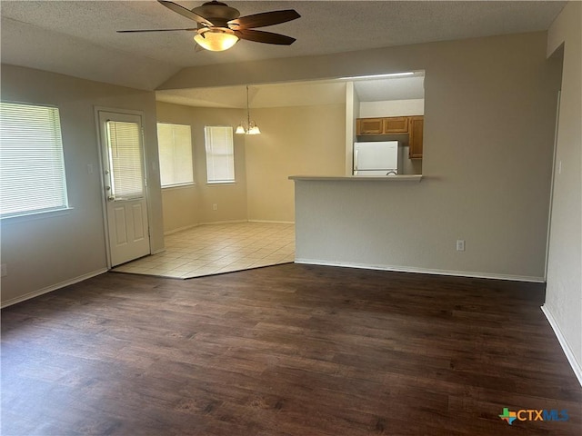 3502 Levy Ln, Killeen, TX 76542 - unfurnished living room with a ceiling fan, a chandelier, wood finished floors, vaulted ceiling, and a textured ceiling