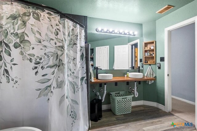 713 End O Trl, Harker Heights, TX 76548 - bathroom featuring wood finished floors, a shower with shower curtain, and double vanity