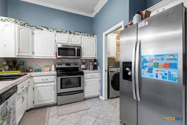 713 End O Trl, Harker Heights, TX 76548 - kitchen featuring stainless steel appliances, washer / clothes dryer, tasteful backsplash, white cabinets, and crown molding