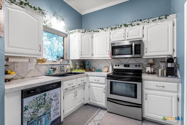 713 End O Trl, Harker Heights, TX 76548 - kitchen featuring appliances with stainless steel finishes, tile countertops, ornamental molding, white cabinets, and decorative backsplash