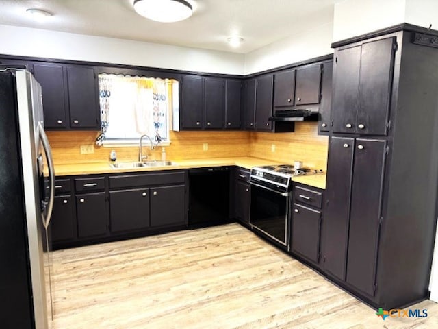 kitchen featuring sink, stainless steel fridge, decorative backsplash, white gas range oven, and light hardwood / wood-style flooring