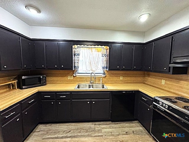 kitchen with sink, light hardwood / wood-style flooring, range hood, black appliances, and a textured ceiling