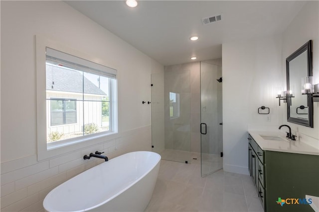 4324 Cedar Creek Rd, Temple, TX 76504 - bathroom featuring a freestanding bath, double vanity, a stall shower, tile patterned flooring, and tile walls