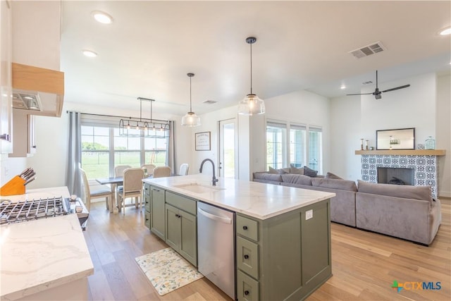 4324 Cedar Creek Rd, Temple, TX 76504 - kitchen with stainless steel appliances, a sink, light wood-style floors, light stone countertops, and a fireplace