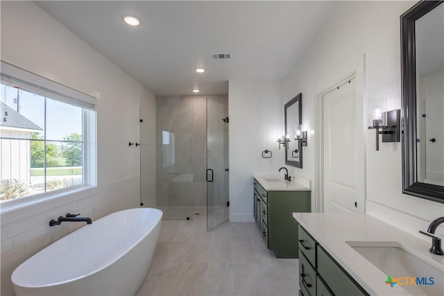 4324 Cedar Creek Rd, Temple, TX 76504 - full bathroom with a shower stall, two vanities, a freestanding bath, recessed lighting, and tile patterned flooring