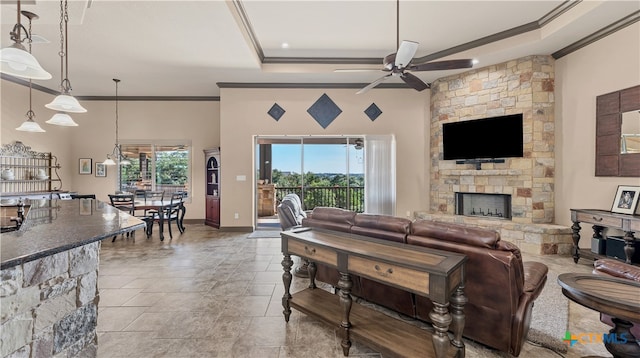 living room with ornamental molding, a fireplace, a towering ceiling, and ceiling fan