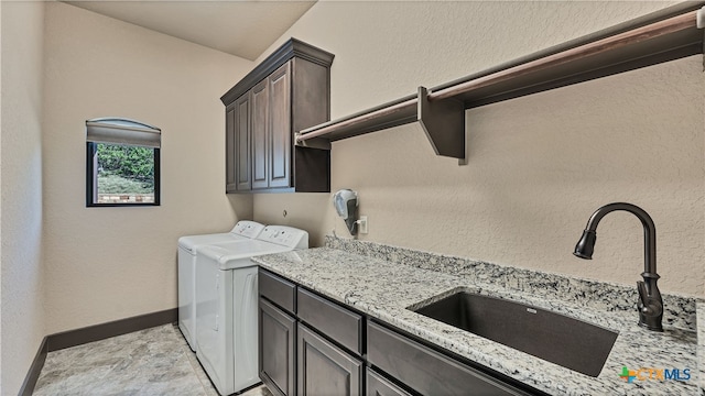 laundry area with cabinets, washer and dryer, and sink