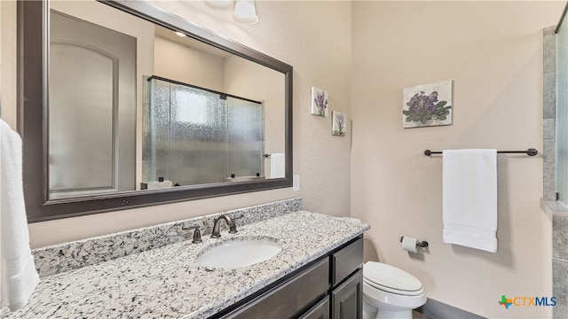 bathroom featuring walk in shower, vanity, and toilet