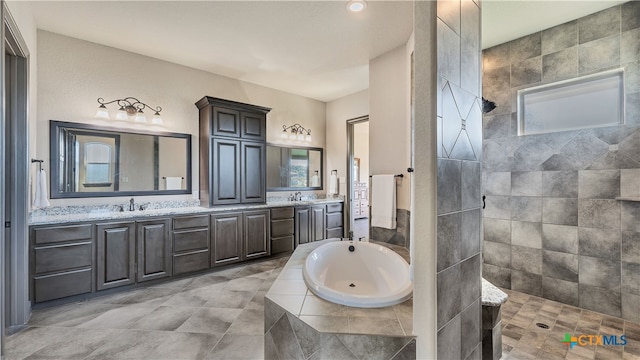 bathroom with tile walls, vanity, and separate shower and tub