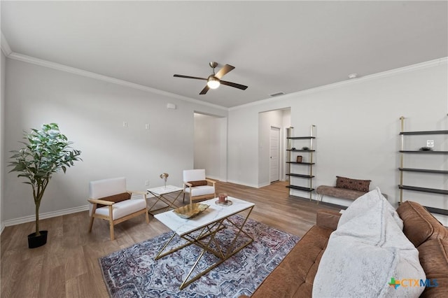 living room with a ceiling fan, baseboards, wood finished floors, and ornamental molding