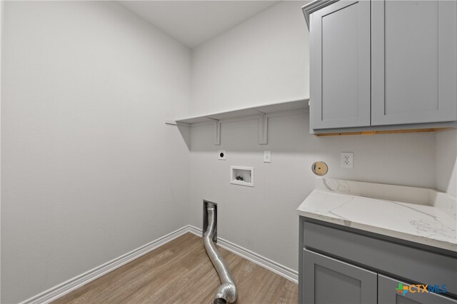 laundry room with hookup for a washing machine, cabinet space, light wood-style floors, electric dryer hookup, and baseboards