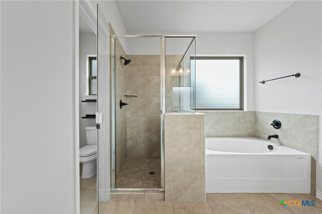 bathroom with toilet, a stall shower, tile patterned flooring, and a bath