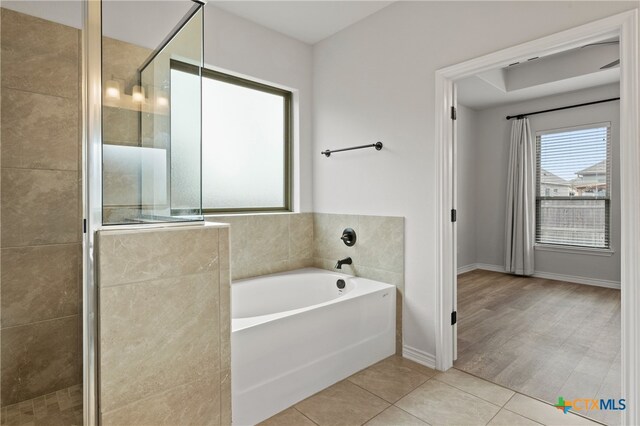 full bath with tile patterned flooring, a shower stall, a bath, and baseboards