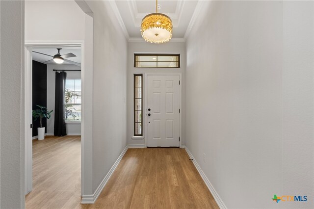 entrance foyer with baseboards, light wood-type flooring, and crown molding