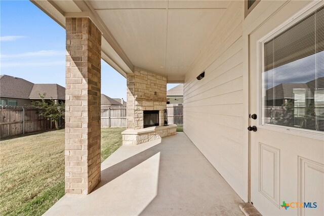 view of patio / terrace with a fenced backyard and an outdoor stone fireplace