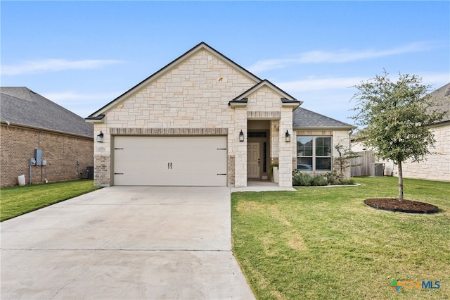 view of front of property featuring a garage, a front yard, and central AC