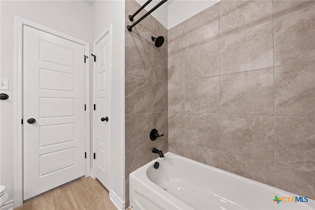 full bathroom with toilet, shower / tub combination, and wood finished floors