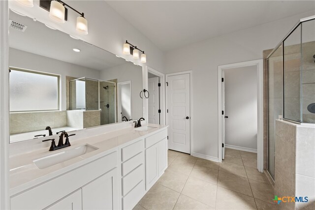 full bathroom with a stall shower, tile patterned flooring, visible vents, and a sink