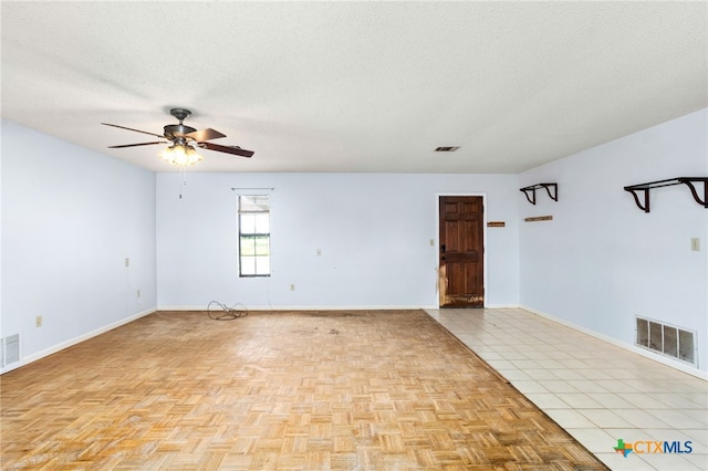 tiled empty room featuring a textured ceiling and ceiling fan