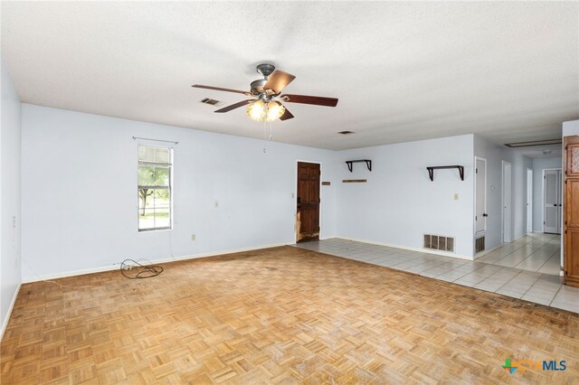 tiled spare room featuring a textured ceiling and ceiling fan