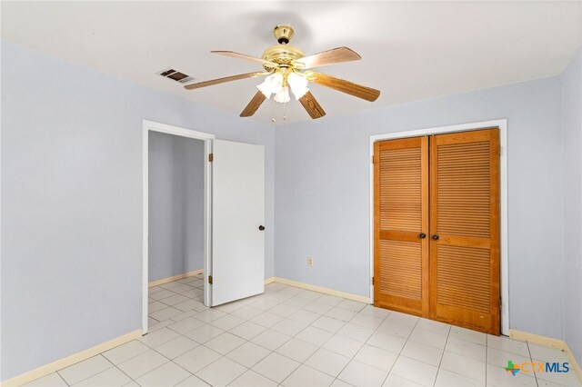 unfurnished bedroom with light tile patterned floors, ceiling fan, and a closet