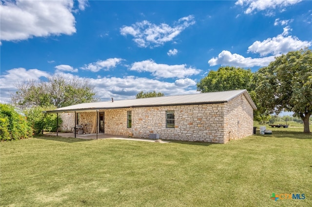 rear view of house with a patio and a yard