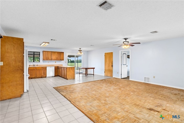 kitchen featuring kitchen peninsula, ceiling fan, a textured ceiling, light tile patterned floors, and white appliances