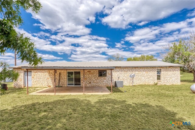 back of property with central air condition unit, a patio area, and a yard