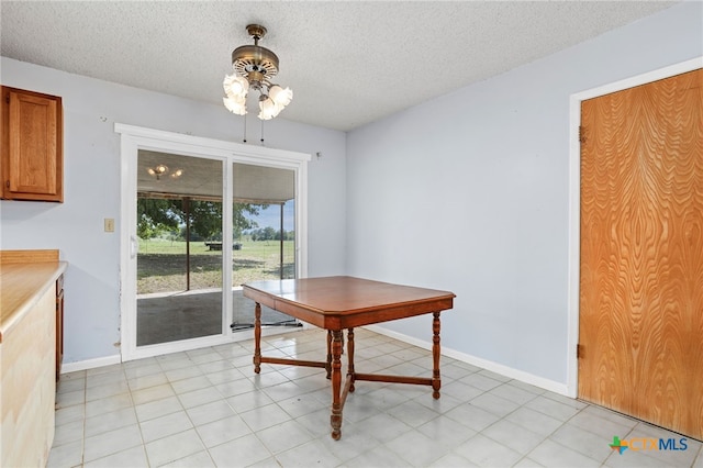 tiled dining room with a textured ceiling