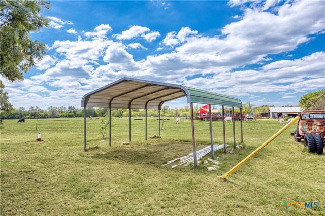 view of parking / parking lot featuring a lawn and a carport