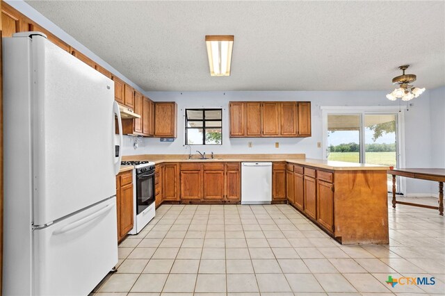 kitchen featuring kitchen peninsula, white appliances, sink, and a textured ceiling