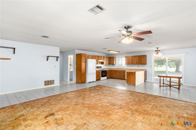 kitchen featuring a textured ceiling, ceiling fan with notable chandelier, light tile patterned floors, and white appliances