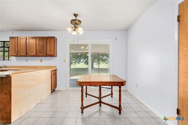 kitchen with a textured ceiling and light tile patterned floors