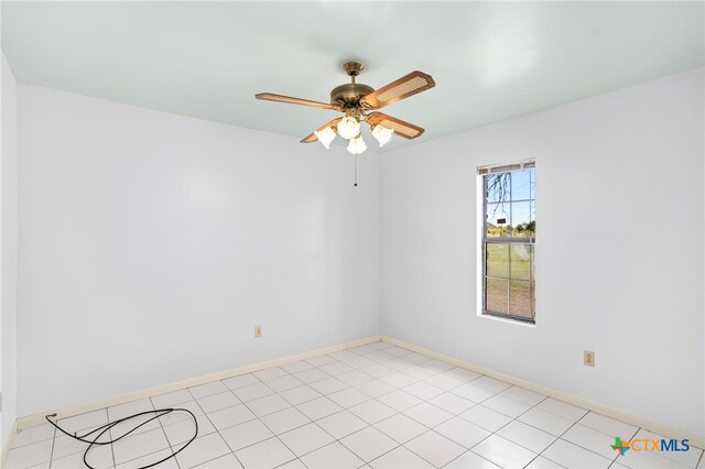 empty room with ceiling fan and light tile patterned floors